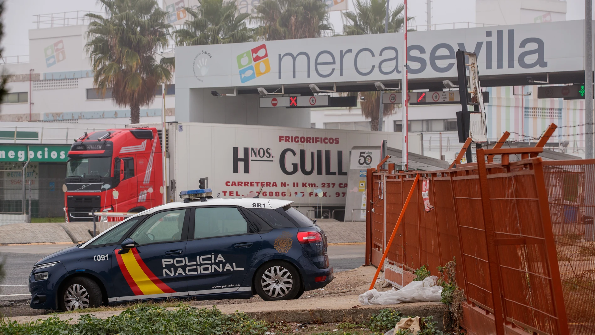Un coche de la Policía Nacional pasa por Mercasevilla, cerca de Torreblanca. EFE/ Julio Muñoz