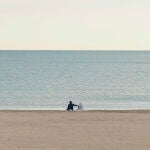 Dos personas disfrutan de la tranquilidad de la playa de la Malvarrosa