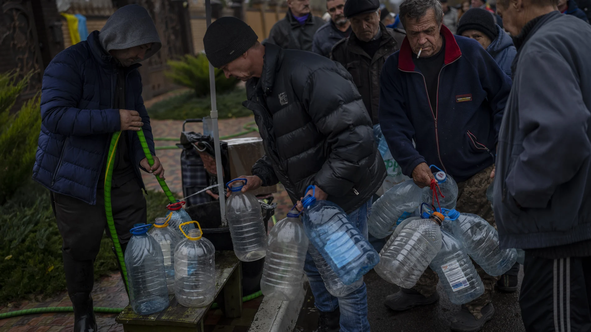 Los residentes llenan contenedores con agua potable en Jersón, este domingo