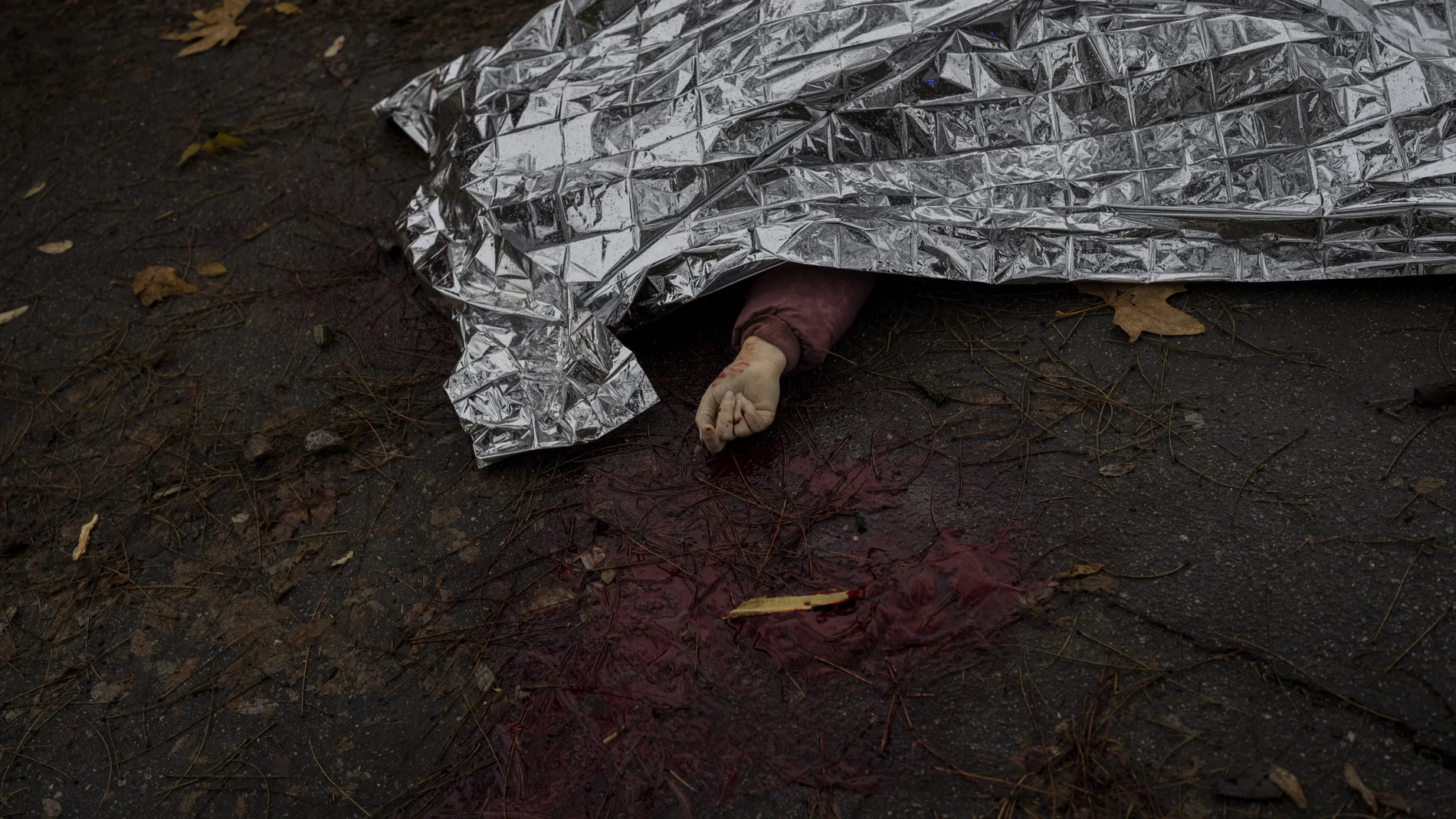 El cuerpo de una mujer muerta durante un ataque ruso es cubierto con una manta de emergencia antes de ser transportado a la morgue en Jersón