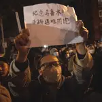 Un manifestante chino sostiene un papel blanco en señal de protesta en Pekín