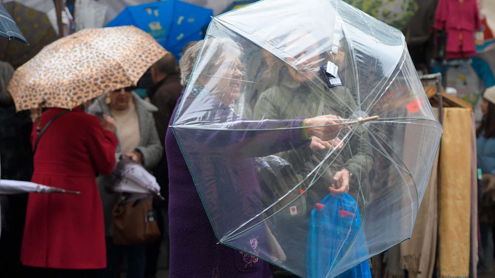 Dos mujeres comprueban un paraguas en un mercadillo de Oviedo