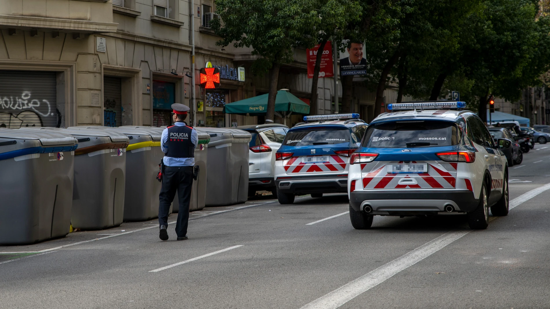 Un Agente de Policía controla la zona donde se encontró encontrado un cadáver en un contenedor del centro de Barcelona. Lorena Sopêna / Europa Press