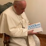 El Papa hojea la memoria que recoge la labor realizada por la Asociación de Voluntarios de CaixaBank, la Fundació del Convent de Santa Clara y Mensajeros de la Paz