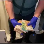 Un agente cuenta parte del dinero incautado durante la operación