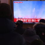 Varias personas ven una noticia en TV sobre los disparos de artillería de Corea del Norte