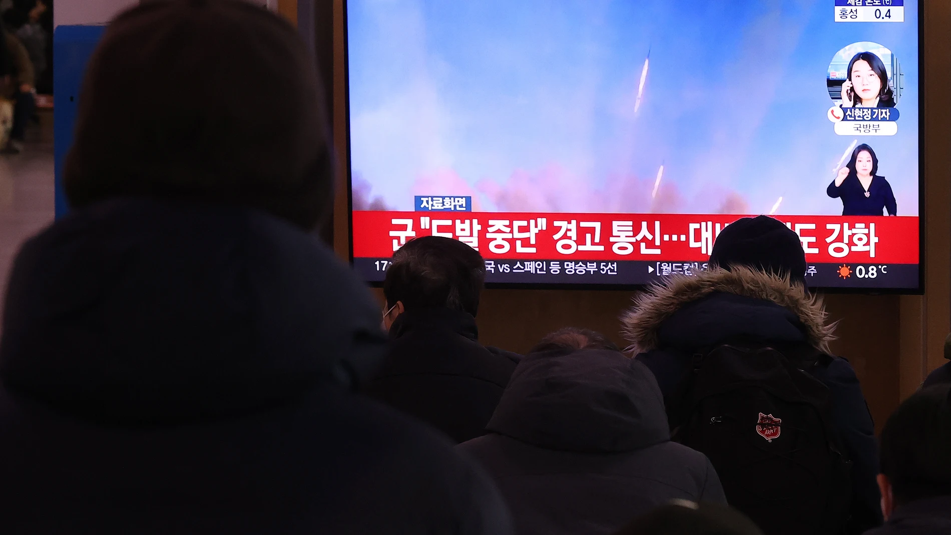 Varias personas ven una noticia en TV sobre los disparos de artillería de Corea del Norte