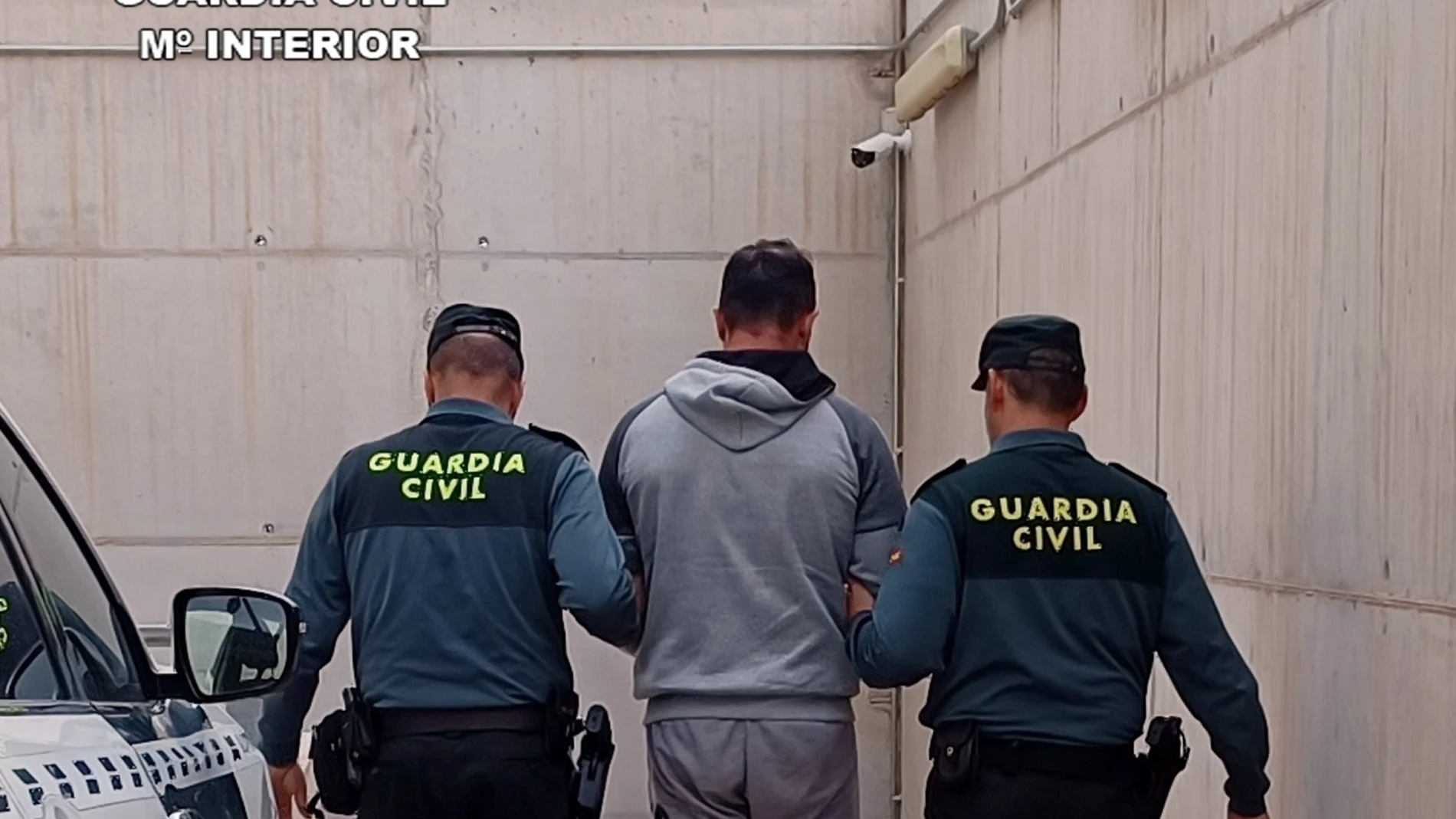 El detenido, custodiado por dos agentes de la Guardia Civil