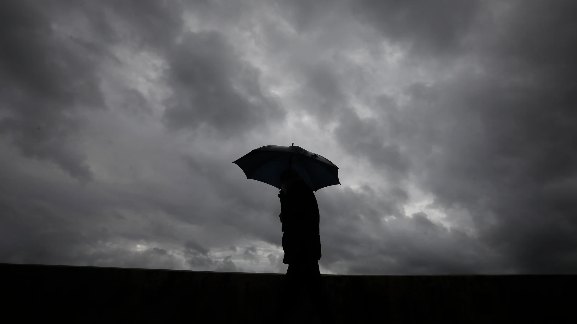 Un hombre se protege de la lluvia en Córdoba