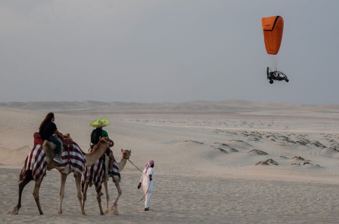 Turistas dan un paseo en camello al atardecer en el primer día sin partidos en Qatar 2022