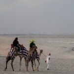 Turistas dan un paseo en camello al atardecer en el primer día sin partidos en Qatar 2022