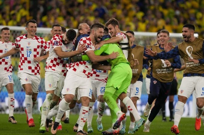 Dominik Livakovic, portero de Croacia, es abrazado por sus compañeros tras derrota a Brasil en los cuartos de final del Mundial