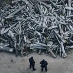 Agentes de policía con fragmentos de cohetes lanzados por Rusia sobre Jarkov