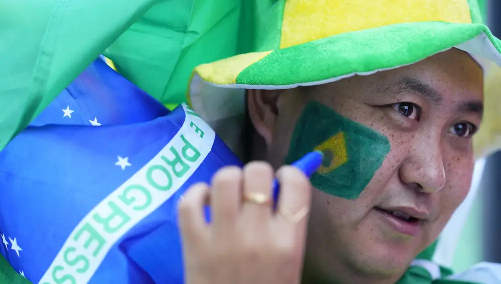 UN fan de la selección de Brasil se pinta la bandera de país en la cara antes del inicio del partido contra Croacia