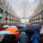 Imagen de archivo de varias personas con paraguas en Málaga