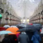 Imagen de archivo de varias personas con paraguas en Málaga