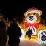 Dos niños posando con un oso navideño de gran tamaño en el Christmas Village en Port Bacares, Francia