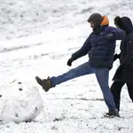 Un hombre patea una gran bola de nieve en Richmond Park, al suroeste de Londres
