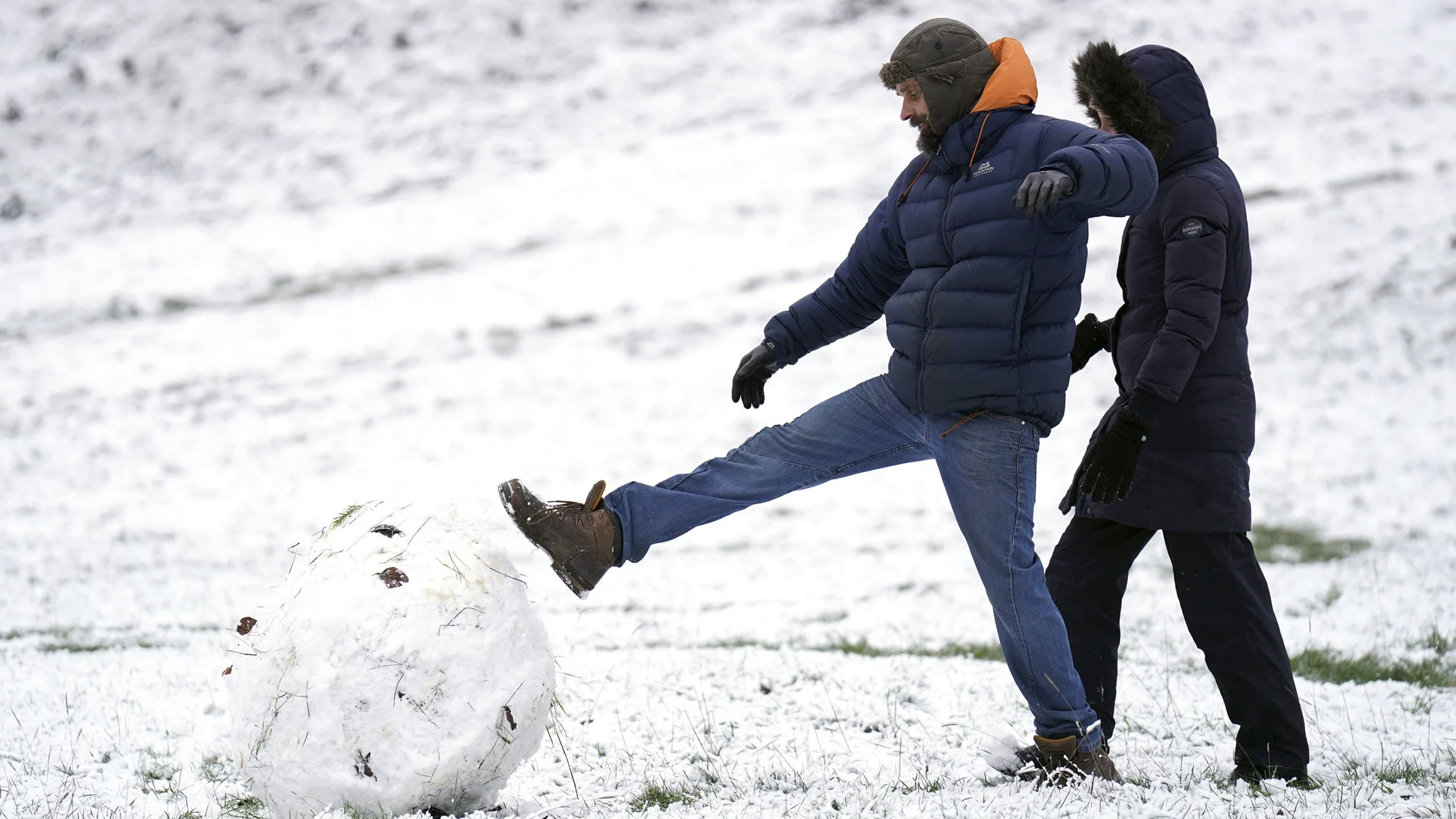 Un hombre patea una gran bola de nieve en Richmond Park, al suroeste de Londres