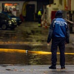 Un agente de Policía en una balsa de agua de una gasolinera, en la Avenida de la Ciudad de Barcelona