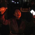 Una mujer grita durante una protesta en Pekín, durante las manifestaciones contra la política "covid cero"