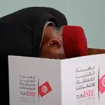 Un tunecino deposita su voto dentro de una urna en un colegio electoral durante las elecciones parlamentarias tunecinas de 2022
