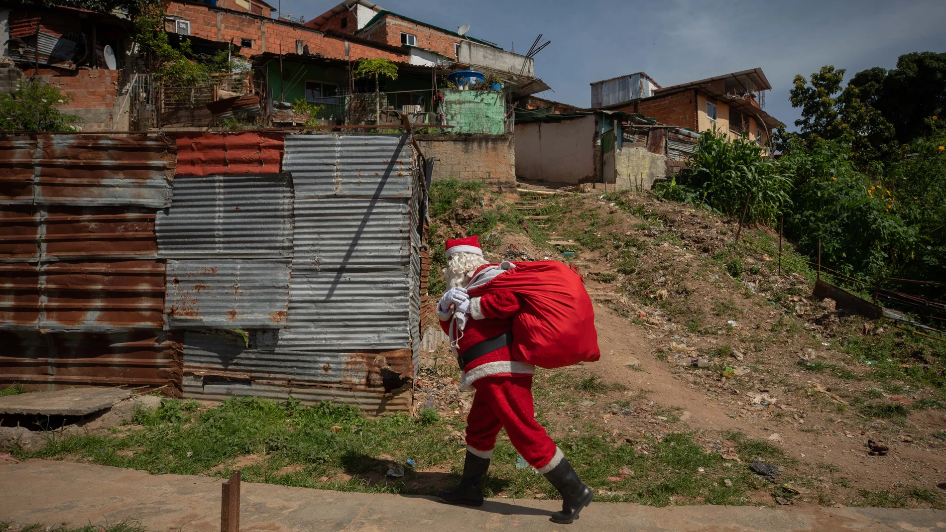 Un hombre vestido de Santa Claus y carga una bolsa de regalos durante la iniciativa "Un Juguete, una buena noticia"