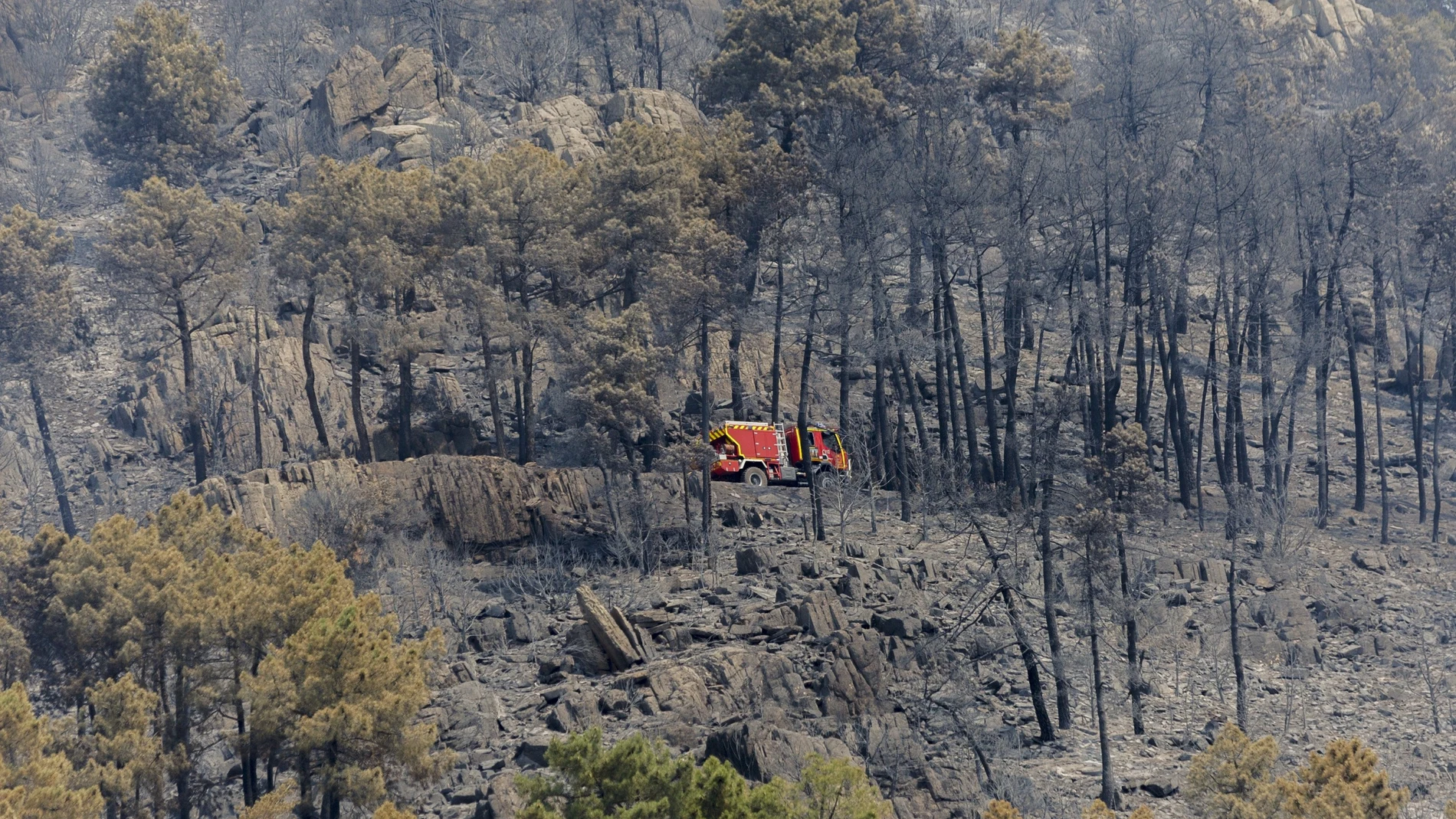 Un camión de bomberos trabaja en la zona del incendio forestal originado en la localidad madrileña de Collado Mediano del pasado mes de julio
