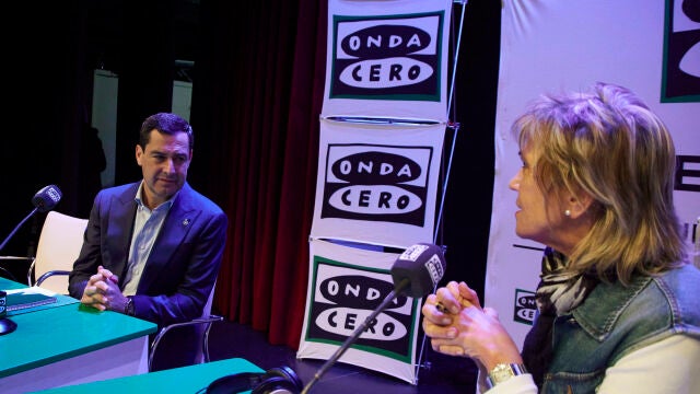 El presidente de la Junta de Andalucía, Juanma Moreno, (i) dialoga con la periodista Julia Otero (d) durante el programa ‘Julia en la Onda’ de Onda Cero en la Fundación Cajasol, a 20 de diciembre de 2022 en Sevilla