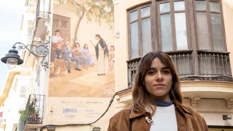 GRAFAND6130. MÁLAGA, 20/12/2022.-La artista barcelonesa Elisa Capdevila posa junto al mural artístico 'Bodas de plata' que decora desde ahora una fachada del casco histórico de la capital malagueña y que se ha inspirado en una de las piezas de la colección permanente del Museo Carmen Thyssen Málaga. EFE/Daniel Pérez