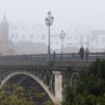El puente de Isabel II conocido como el Puente de Triana, cubierto de niebla