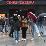 Tres chicas se hacen un &#39;selfie&#39; bajo sus paraguas en Madrid