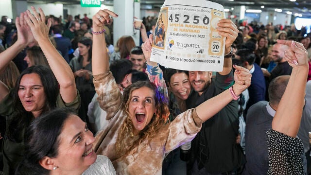 Empleados de la empresa Tragsatec celebran en sus oficinas, situadas en en el polígono industrial de Julián Camarillo, en el distrito de San Blas de Madrid, después de que el número que llevaban, el 45250, haya sido agraciado con el tercer premio de la Lotería de Navidad 2022