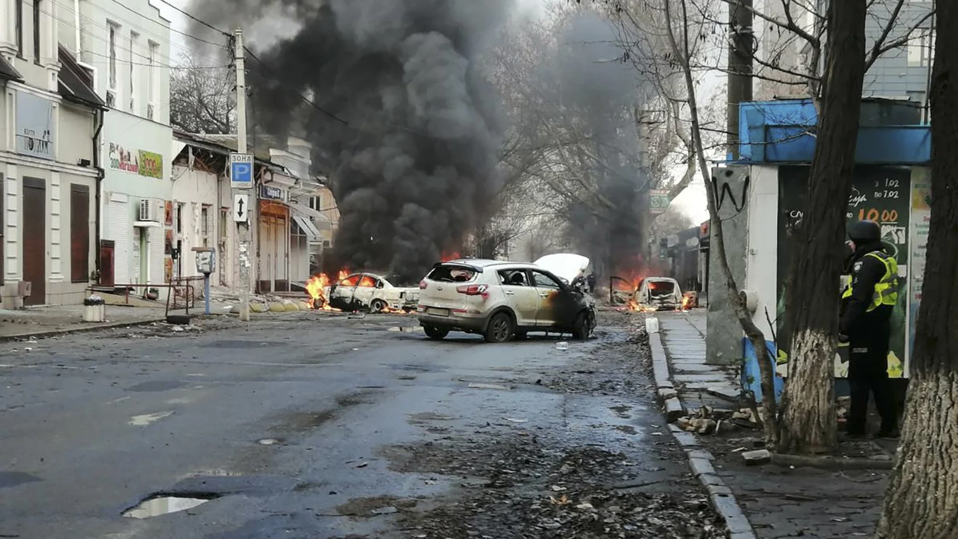Los coches arden y se levanta humo después de que un ataque mortal con cohetes rusos golpeara el centro de la ciudad de Jersón