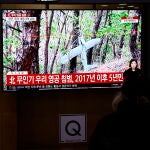 Viajeros ven las noticias por televisión en la estación central de tren de Seúl