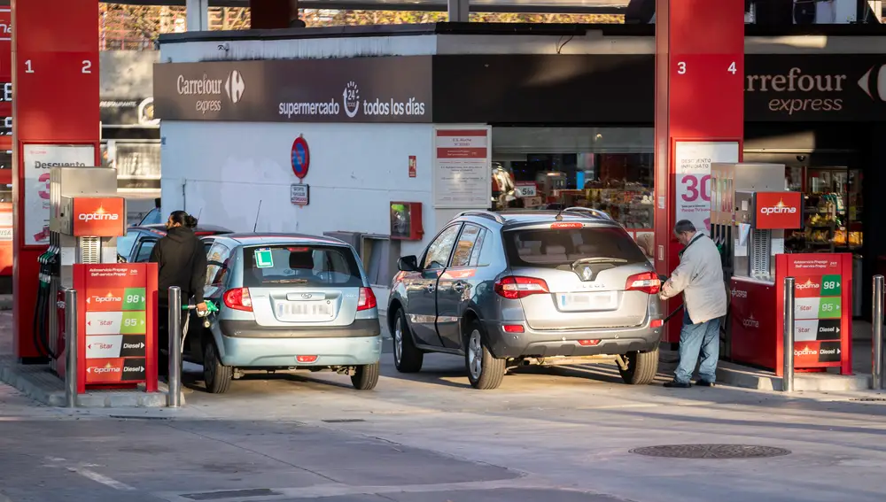 Dos personan repostan combustible en una gasolinera