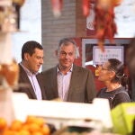 El presidente de la Junta de Andalucía, Juanma Moreno (1i), y el candidato a la alcaldía de Sevilla, José Luis Sanz (2i), dialogan con los vecinos en la plaza de abastos de Triana