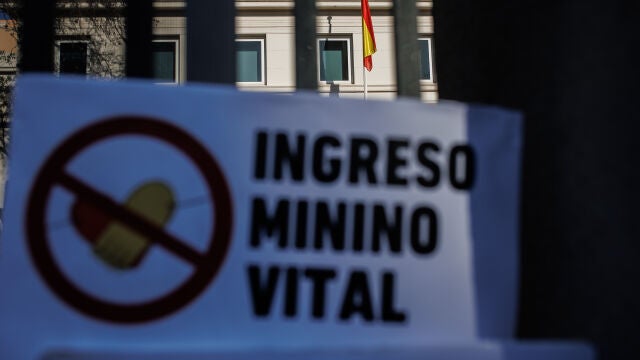 Un cartel en el que se lee: 'Ingreso Mínimo Vital' en las rejas del Ministerio de Inclusión y Seguridad Social