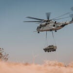 Un Sikorsky CH-53K carga con un vehículo blindado durante las pruebas para su evaluación final