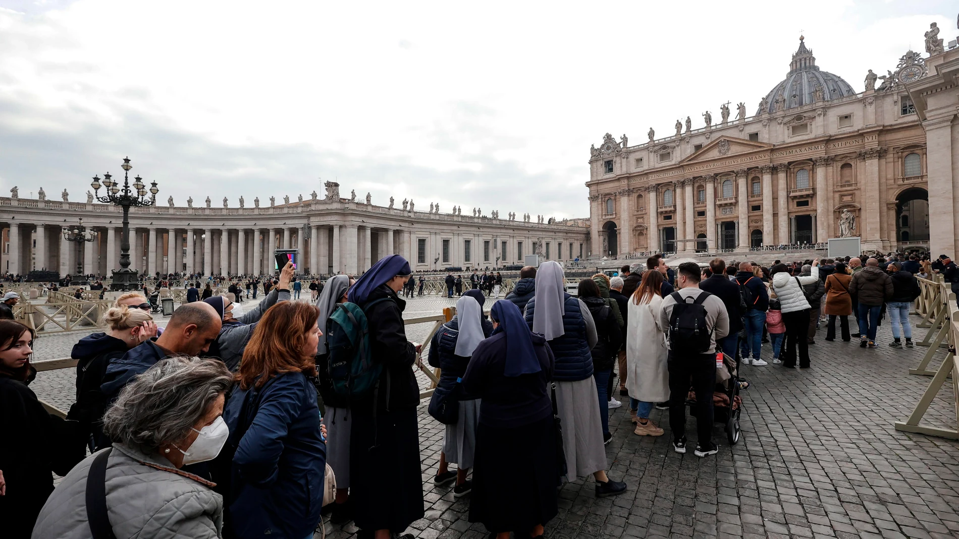 Gente esperando en la plaza de San Pedro para entrar a presentar sus respetos al papa fallecido Benedicto XVI