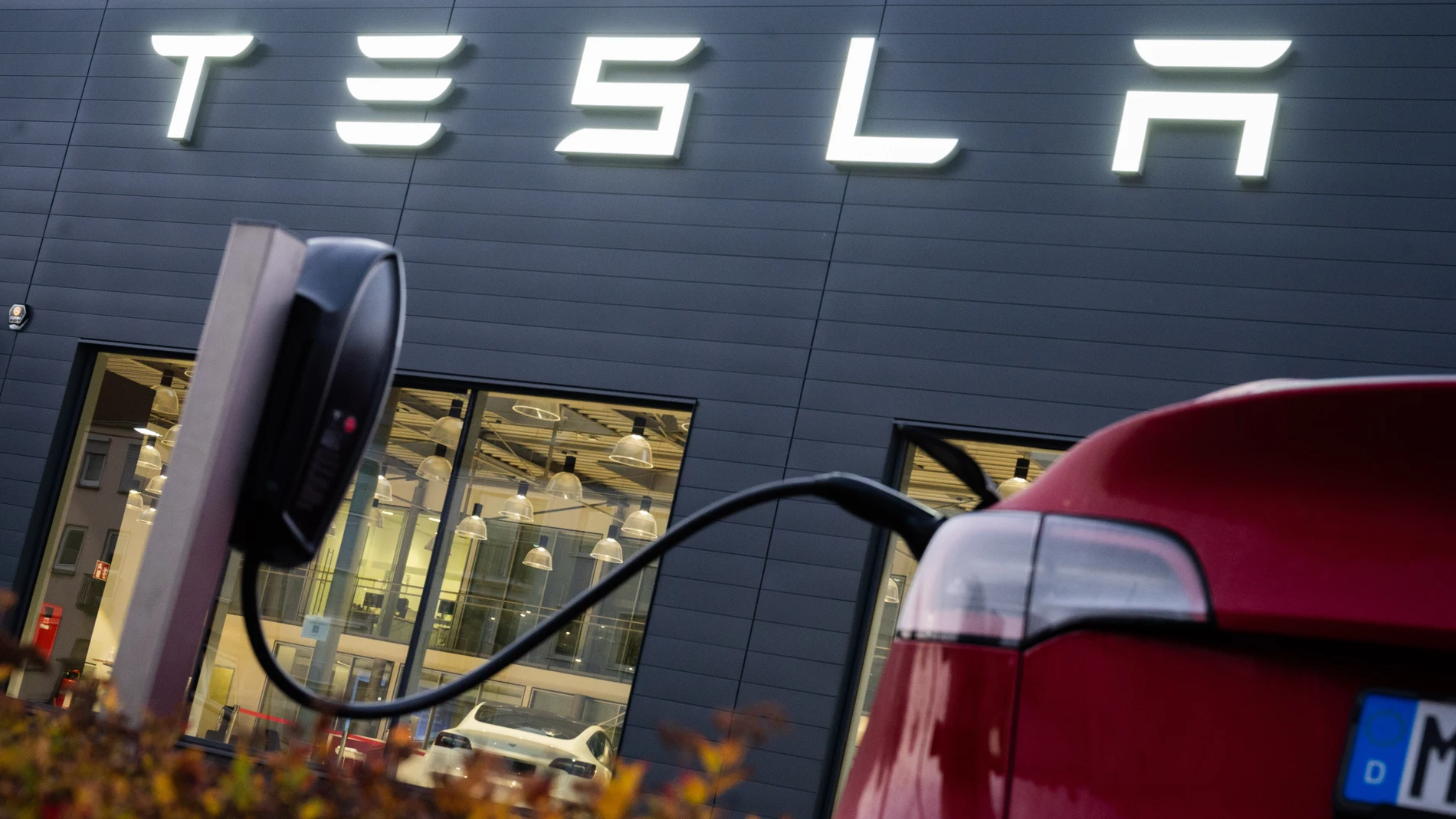 Un Tesla cargando junto a uno de los concesionarios de la marca en Alemania