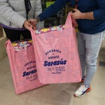 Dos personas sujetan bolsas con regalos de la juguetería de Sarasús, a 5 de enero de 2023, en Madrid