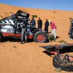 Carlos Sainz y Lucas Cruz tratan de reparar su Audi RS Q e-tron E2 durante la sexta etapa del Dakar 2023