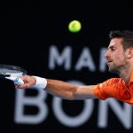 Djokovic devuelve una bola en carrera en la semifinal de Adelaida ante Medvedev