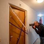 Un cámara fotografía el precinto policial en la entrada a la vivienda de El Puerto de Santa Maria (Cádiz) donde este domingo ha sido asesinada una mujer a manos de su pareja