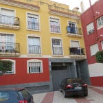 Vista del portal de la calle Las Palmeras de Roquetas de Mar y el edificio en el que ha tenido lugar el crimen