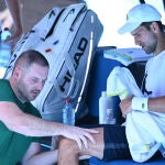 Novak Djokovic es tratado por el fisio en su primer entrenamiento en Melbourne antes del Open de Australia
