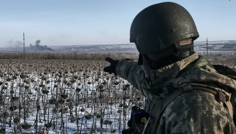 Un soldado ucraniano señala el humo que se levanta en su posición en la línea del frente cerca de Soledar