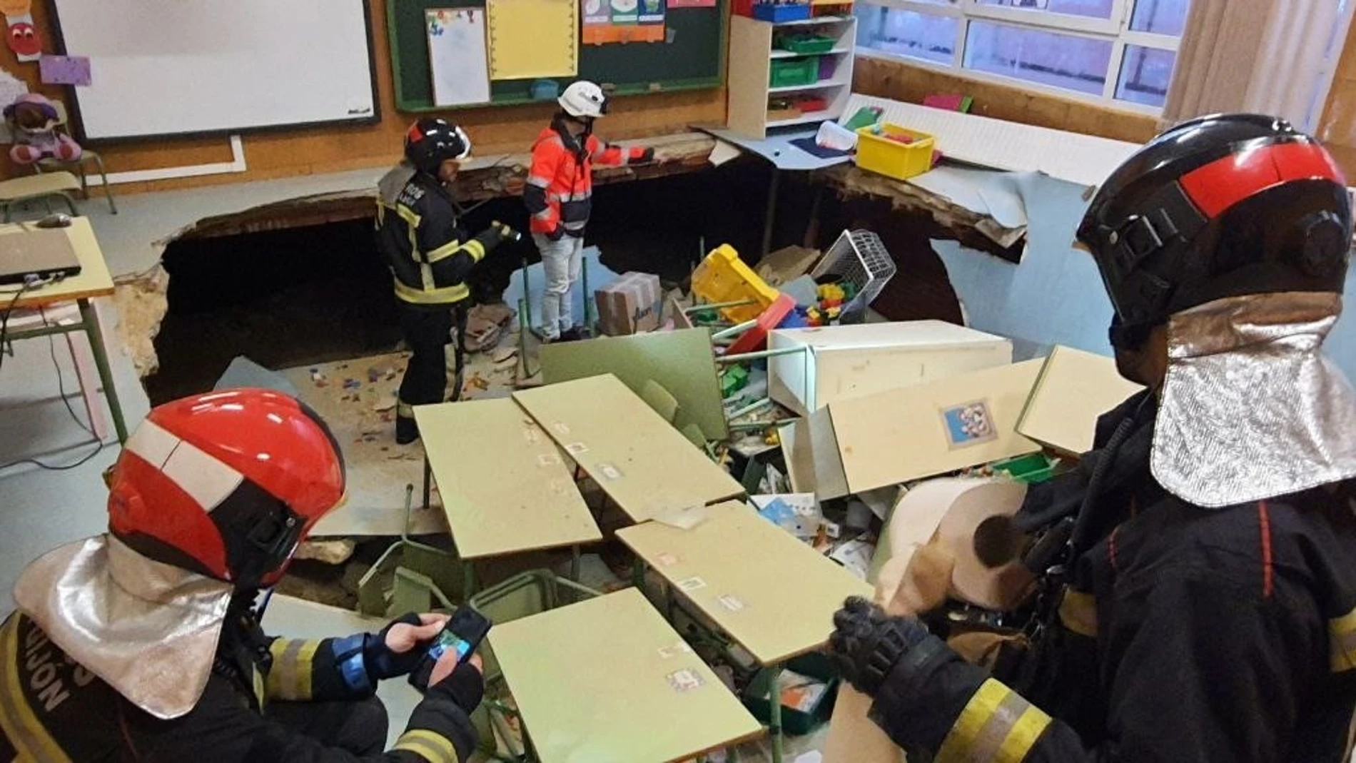 Bomberos de Gijón inspeccionan un aula de Infantil del colegio público Rey Pelayo tras derrumbarse el suelo, en Gijón