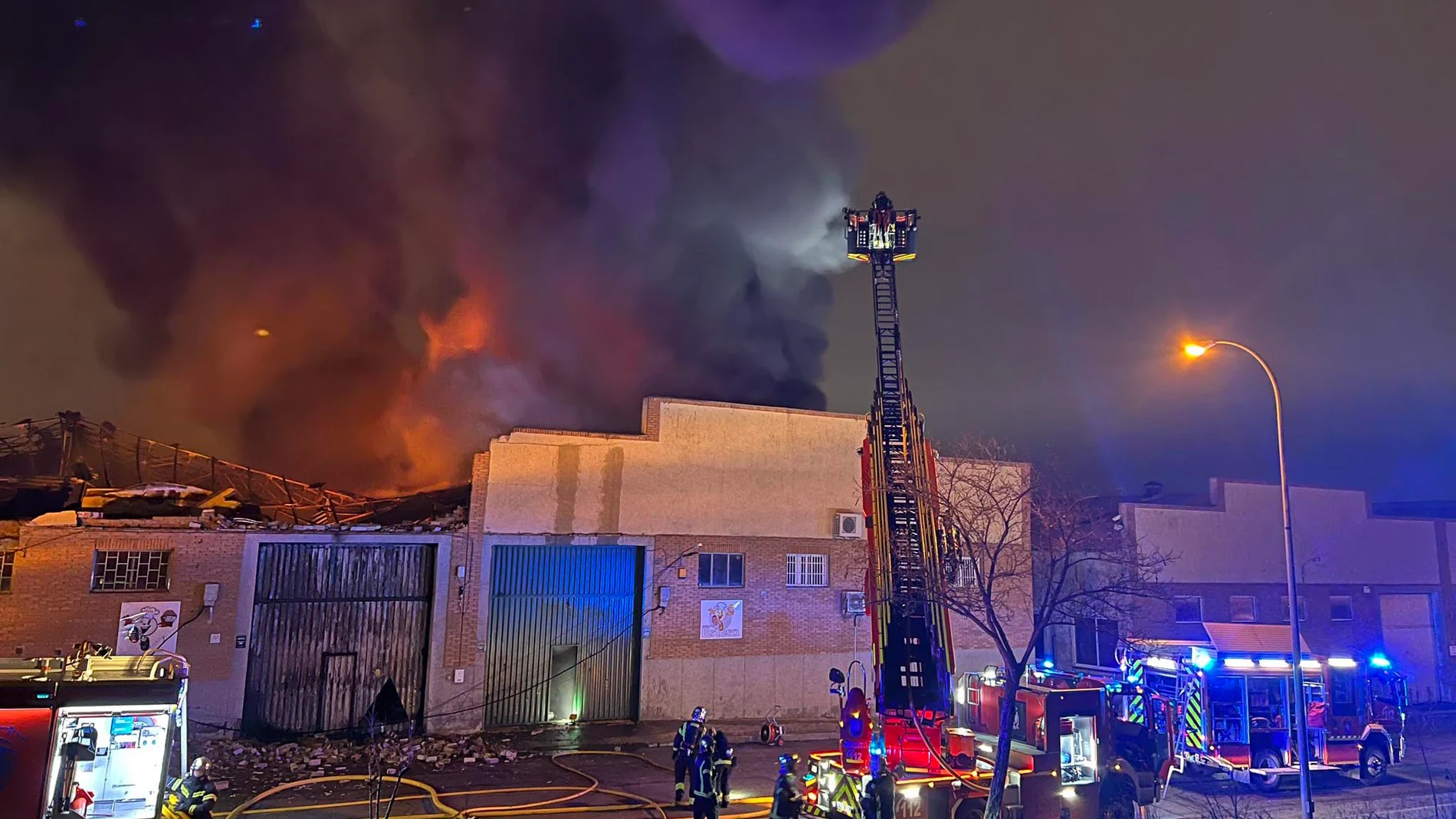 fectivos del cuerpo de bomberos trabajan en las labores de extinción del incendio que ha destruido una nave industrial dedicada a la repostería situada en el Polígono Cobo Calleja de Fuenlabrada